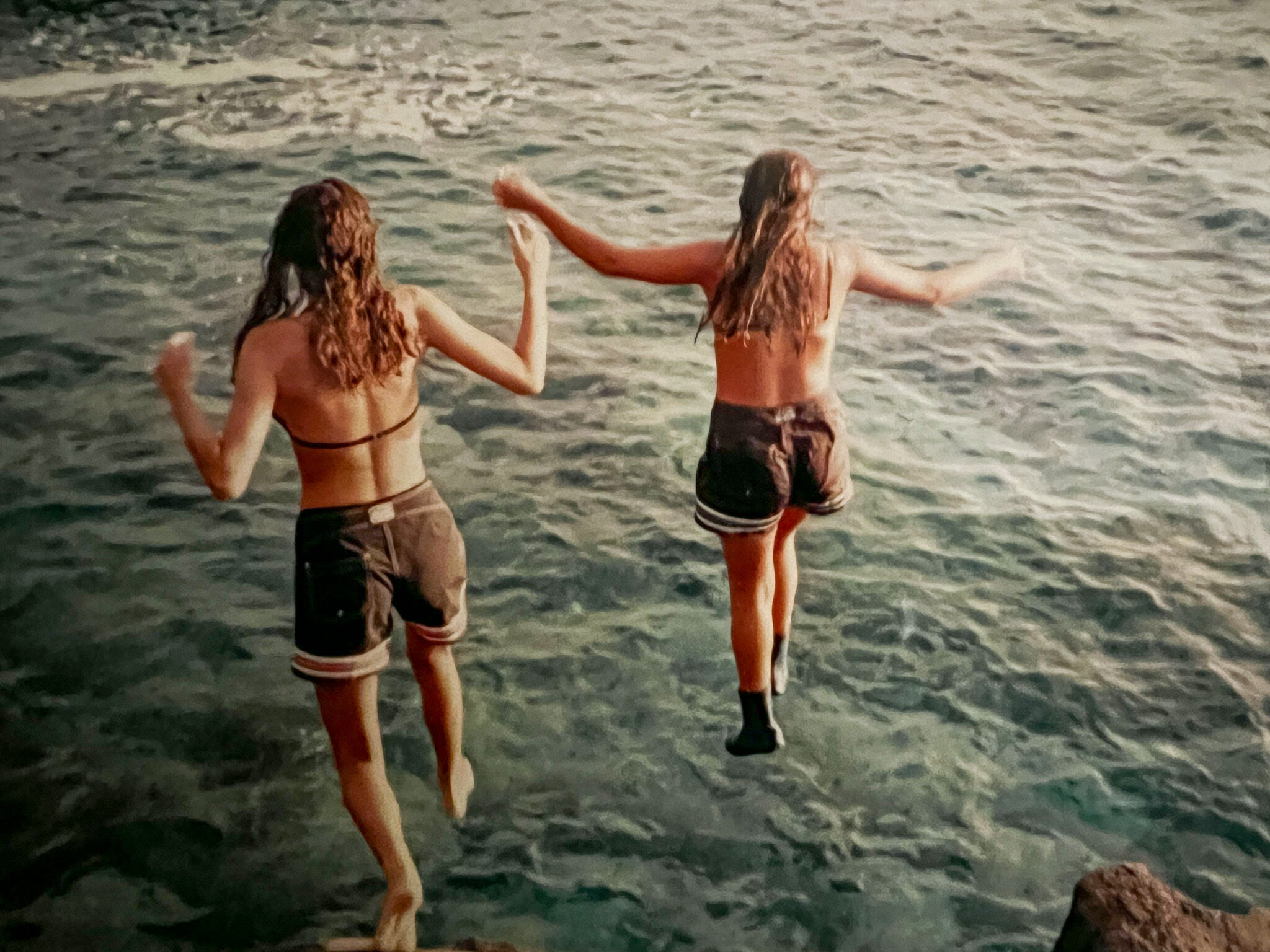 two girls jumping into water